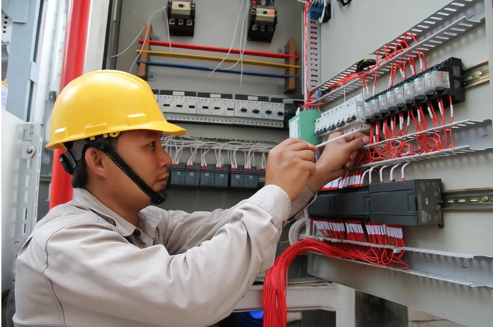 Thợ sửa điện chuyên nghiệp tại Hải Phòng đang đấu nối, sửa chữa tủ điện công nghiệp một cách cẩn thận.